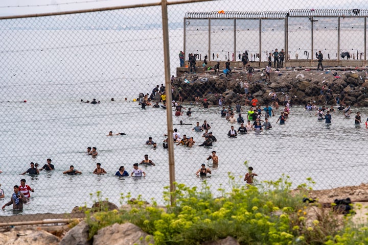 Migrants try to cross from Morocco into the Spanish enclave of Ceuta on Friday.