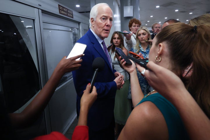 Sen. John Cornyn answers questions from reporters trailing after him following a vote in the U.S. Capitol on July 30, 2026 in Washington, D.C.