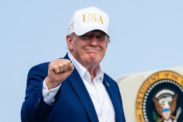 President Donald Trump gestures as he boards Air Force One on Sunday at Morristown Airport in Morristown, New Jersey. Trump spent the weekend at his Bedminster, New Jersey golf club.