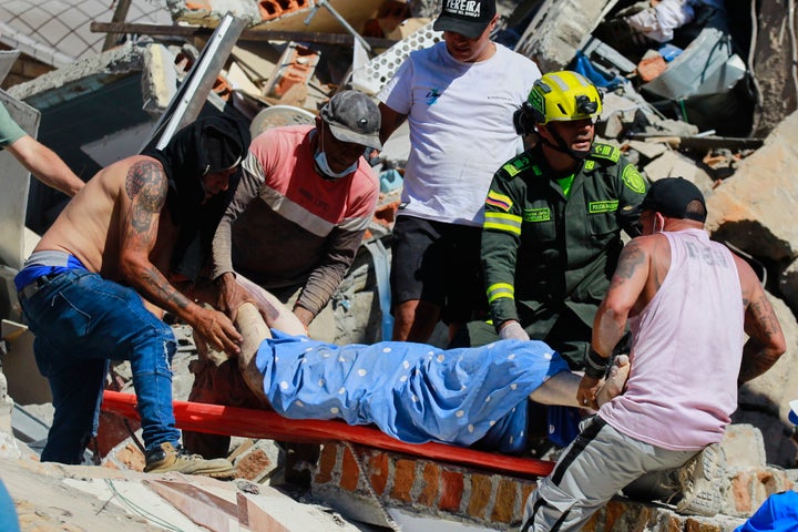 Residents and police carry a survivor pulled from the rubble after an earthquake struck Pereira, Colombia, Monday, Aug. 10, 2026. (AP Photo/Miguel Angel Lopez)