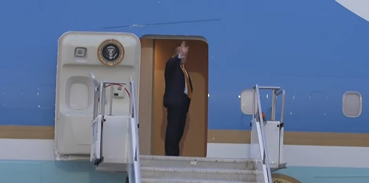 President Donald Trump turns and waves as he boards Air Force One in Turkey. However, it was later reported that he secretly left the aircraft in a catering container and flew in a military jet instead. 