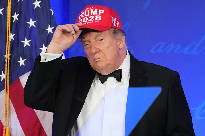President Donald Trump shows off a Trump 2028 hat at the White House Correspondents' Association dinner on July 24 in Washington.