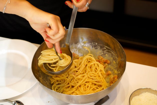 A woman spoons onto a plate some 
