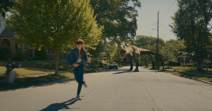 Anne Hathaway's character flees a dinosaur attack in her new movie The End Of Oak Street