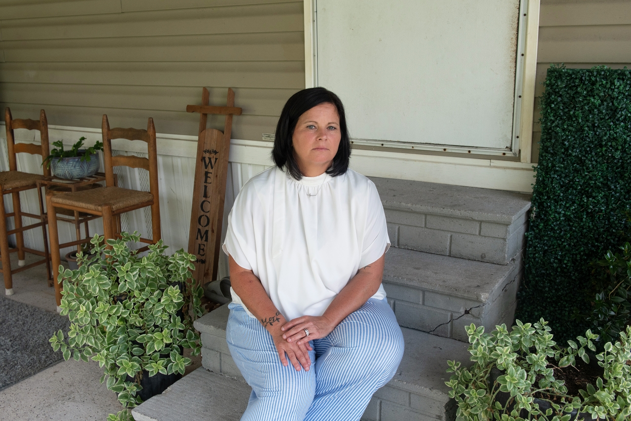Rhonda Jewell seated in front of her home. 