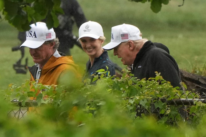 Interior Secretary Doug Burgum (left), White House aide Natalie Harp (center) and President Donald Trump (right) walk around Washington, D.C.’s East Potomac Park golf course in June.