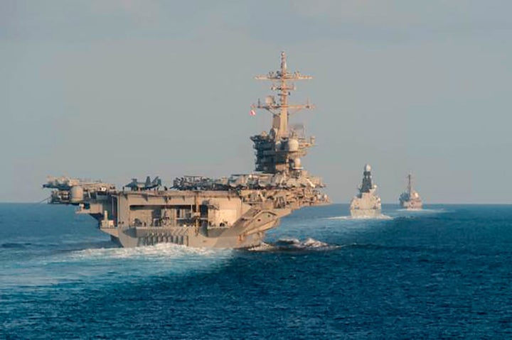 In this Nov. 19, 2019, photo made available by U.S. Navy, the aircraft carrier USS Abraham Lincoln (L), the air-defense destroyer HMS Defender and the guided-missile destroyer USS Farragut transit the Strait of Hormuz with the guided-missile cruiser USS Leyte Gulf.