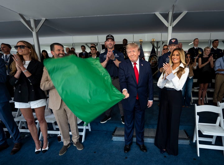 President Donald Trump waves the green flag as first lady Melania Trump stands at his side during the Freedom 250 Grand Prix race on Sunday. (Photo by Doug Mills/Pool/AFP via Getty Images)