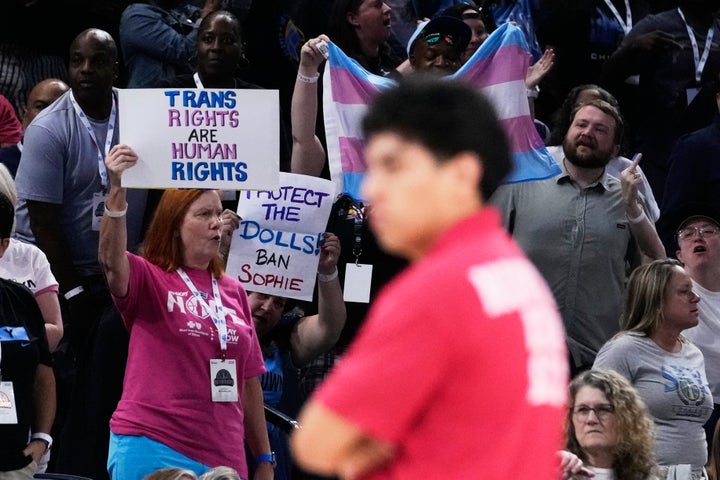 Fans hold signs supporting trans rights during the second half of a WNBA game between the Indiana Fever and Chicago Sky on Aug. 23, 2026, in Chicago.