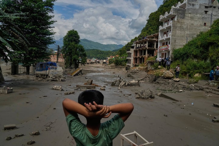 A boy looks at the devastation caused by flash flooding along the Trishuli River in Nepal's Nuwakot district, Wednesday, Aug. 26, 2026. (AP Photo/Niranjan Shrestha)