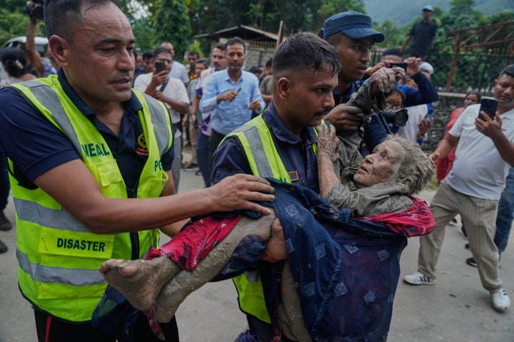 Rescuers carry a victim of flash flooding to safety along the Trishuli River in Nepal's Nuwakot district, Wednesday, Aug. 26, 2026. (AP Photo/Niranjan Shrestha)