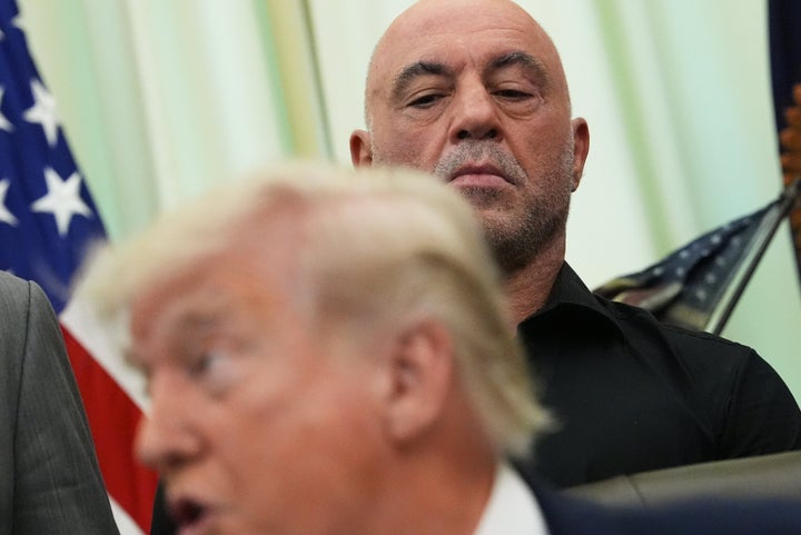 Joe Rogan listens to President Donald Trump speak in the Oval Office of the White House on April 18.