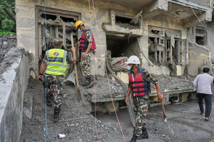 Rescuers inspect a residential building damaged in the aftermath of the flash floods in Nepal's Nuwakot district, on Sept. 2, 2026.