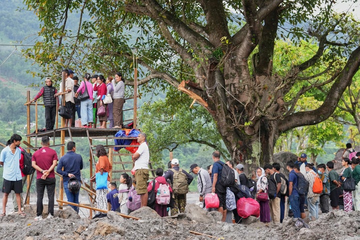 People wait to board a trolley on a zip line constructed to transport stranded citizens across the Trishuli river following flash floods, in Nepal's Nuwakot district, on Sept. 3, 2026.
