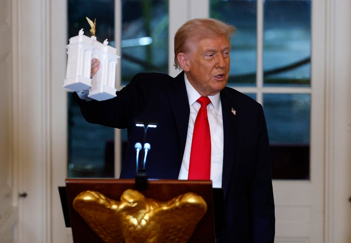 Trump holds a model of the arch he wants built on October 15, 2025. 