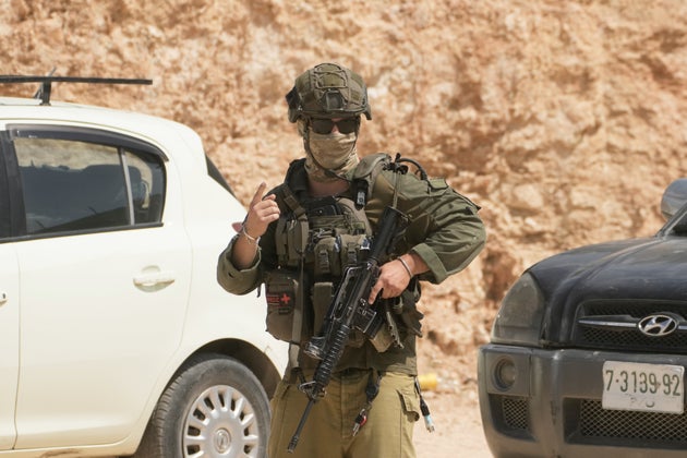 An Israeli soldier patrols the site of an attack by Israeli settlers on Palestinian properties in the occupied West Bank village of Qusra, Saturday, Aug. 29, 2026. 