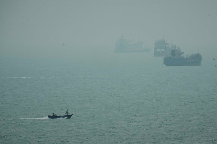 A motorboat travels past commercial vessels anchored amid haze in the Strait of Hormuz off Bandar Abbas, Iran, Monday, Sept. 7, 2026. (AP Photo/Vahid Salemi)