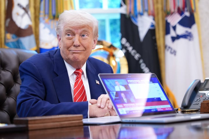 U.S. President Donald Trump shows a news video from a laptop in the Oval Office of the White House on May 30, 2025, in Washington, D.C.