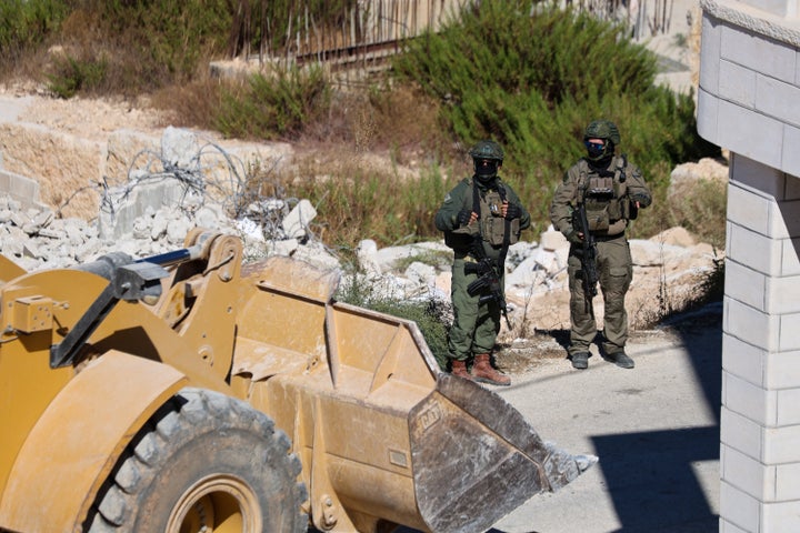 Two Israeli soldiers stand beside rubble and a front loader near a demolition site in Battir, in the occupied West Bank, on Sept. 10, 2026. Battir Mayor Akram Badr told WAFA that Israeli forces entered the village with military bulldozers and demolished the 170-square-meter home of Mohammad Shaher Oweina in Al-Zqaq.