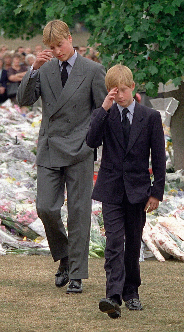 Prince William, left, and Prince Harry, right, gesture after they arrived at Kensington Palace to view some of the flowers and mementos left in memory of their mother on Sept. 5, 1997.