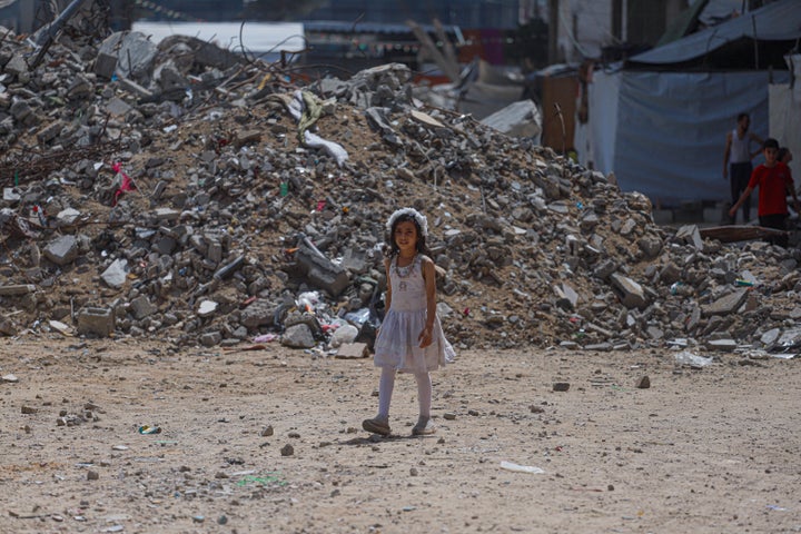 A Palestinian girl walks past a pile of rubble toward the tent-based Al-Itqan School in the Al-Saftawi neighborhood in Gaza City on September 19.