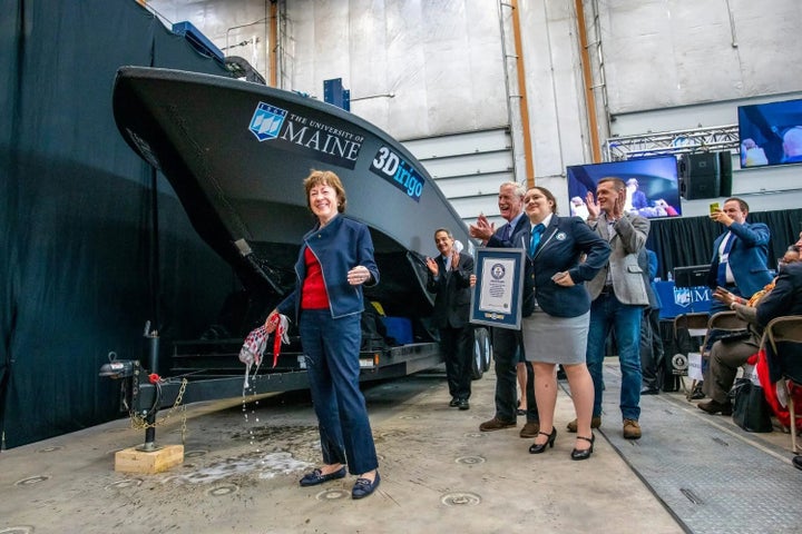 Collins christens a Navatek-designed boat at a University of Maine engineering lab in October 2019