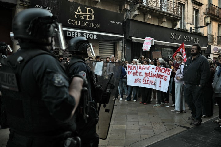 Riot police officers face teachers holding a banner reading "Montaigne - Teachers on strike, in solidarity with the students!" during a demonstration as part of a nationwide protest movement of high-school students over learning conditions in the south-western city of Bordeaux on Oct. 6, 2026.