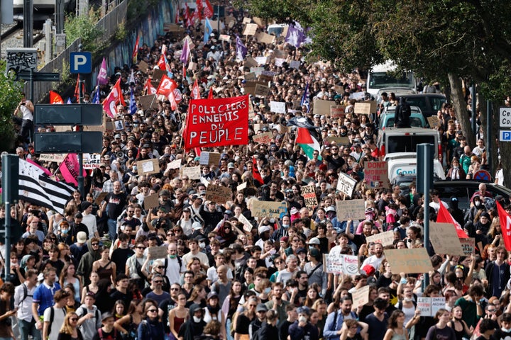 Students with a large red banner reading “Police officers, enemy of the people” march during a protest against under-resourced schools, in Rennes, western France, on Oct. 6.