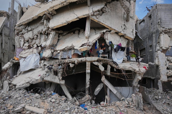 Murid Akhziq, 43, lights a fire for cooking inside his home, which was destroyed during the Israel-Hamas war, in Gaza City, Tuesday, Oct. 6, 2026. (AP Photo/Abdel Kareem Hana)