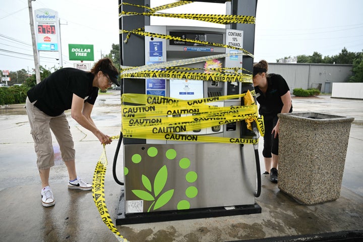Workers cordon off a gas pump with yellow tape at a gas station in Navarre, Florida, on Friday as Hurricane Isaias moves north toward the Florida Panhandle.