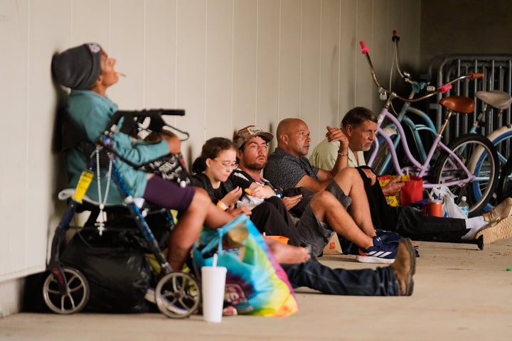 People sit outside an evacuation shelter as Hurricane Isaias approaches Pensacola, Fla., Friday, Oct. 9, 2026. (AP Photo/Gerald Herbert)