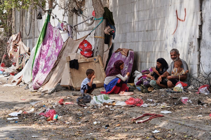 A displaced Yemeni family sits beside a makeshift shelter along a roadside in Aden, Yemen, Sunday, Oct. 11, 2026. (AP Photo/Abdulnasser Alseddik)