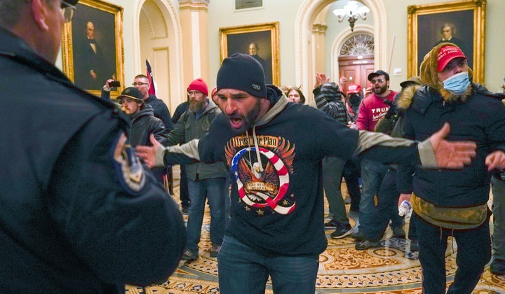 In this Jan. 6, 2021, photo, Trump supporters, including Douglas Jensen (center) confront U.S. Capitol Police in the hallway outside the Senate chamber at the Capitol in Washington.