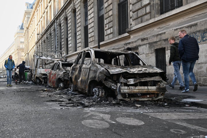 People look at charred cars the day after a demonstration against rising living costs, joining students' grievances, in Paris, Sunday, Oct. 18, 2026. (AP Photo/Emma Da Silva)