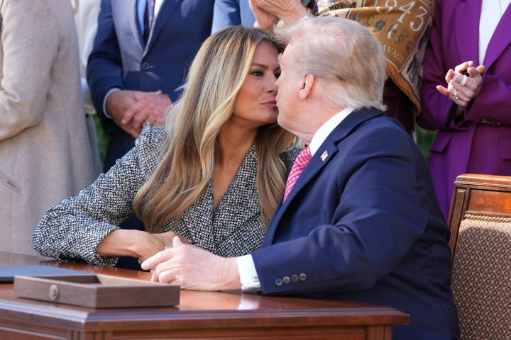 Trump goes in for a kiss after signing an executive order with his wife on Monday.