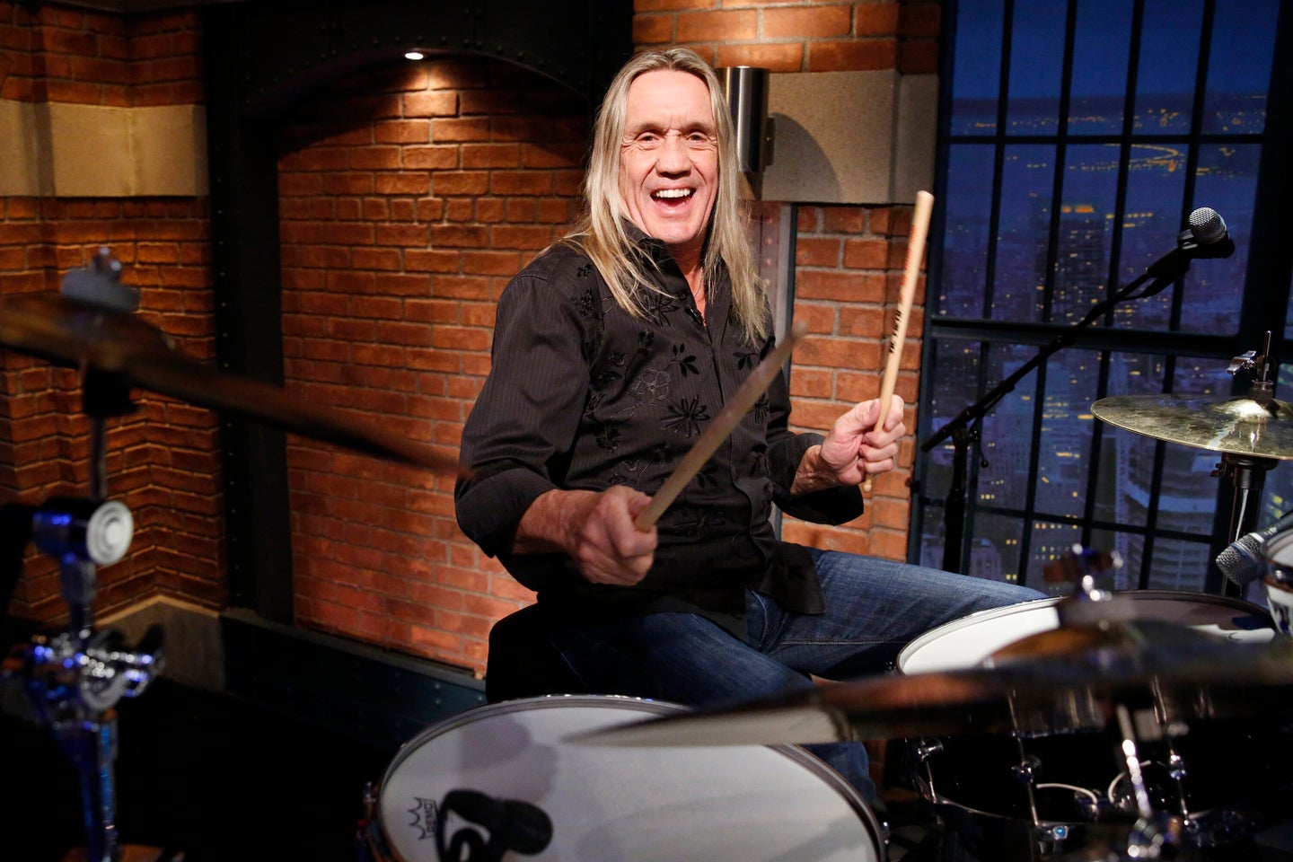 Iron Maiden’s Nicko McBrain sits in with the 8G Band on “Late Night With Seth Meyers” in this 2017 file photo.