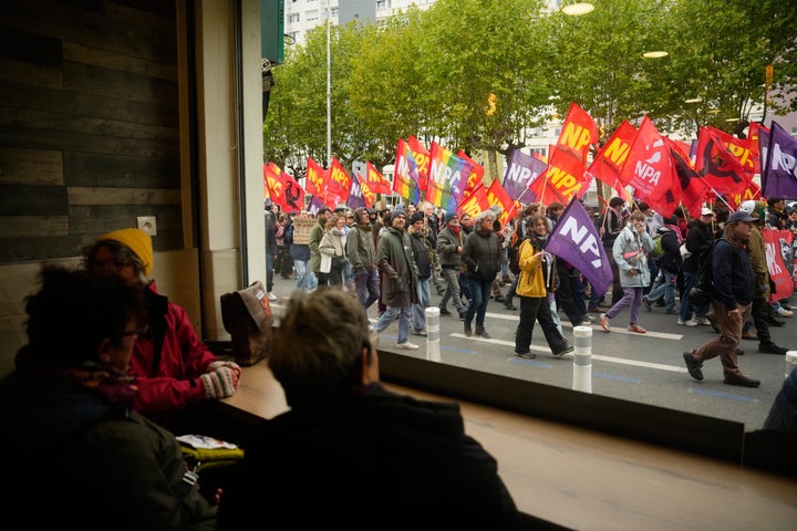 People sitting in a pub watch demonstrators during a protest on the sidelines of the far-right Rassemblement National (RN) congress in Orleans, France, Saturday, Oct. 24, 2026. (AP Photo/Teresa Suarez)