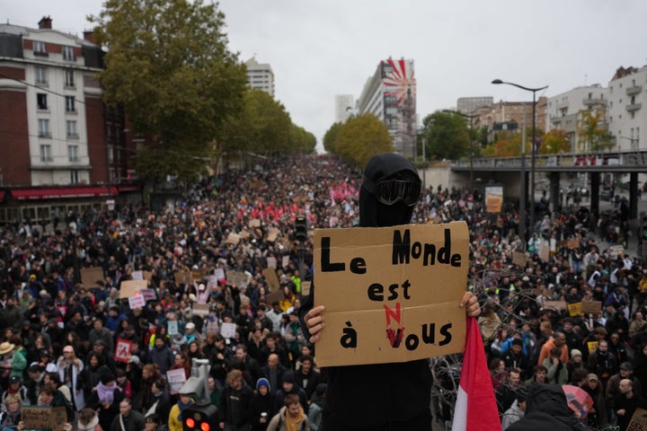 A protesters holds a board reading "The world is ours" during a demonstration against rising living costs in Paris, Saturday, Oct. 24, 2026. (AP Photo/Thibault Camus)