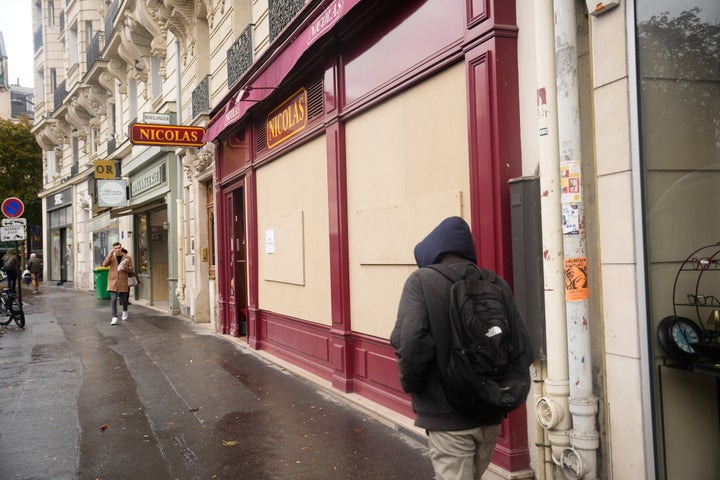 Passersby walk past a boarded-up store on the eve of a demonstration against rising living costs in Paris, Friday, Oct. 23, 2026. (AP Photo/Teresa Suarez)