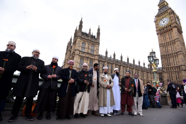 Imãs seguram flores, reunidos na ponte de Westminster antes de uma vigília em memória às vítimas do ataque terrorista da ponte de Westminster.