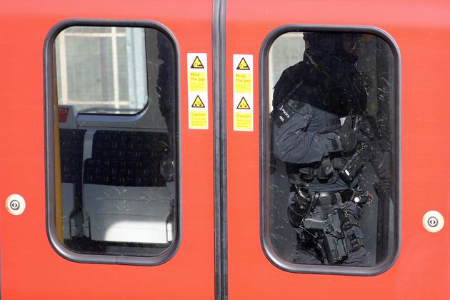 Armed police officers walk through a carriage on the train